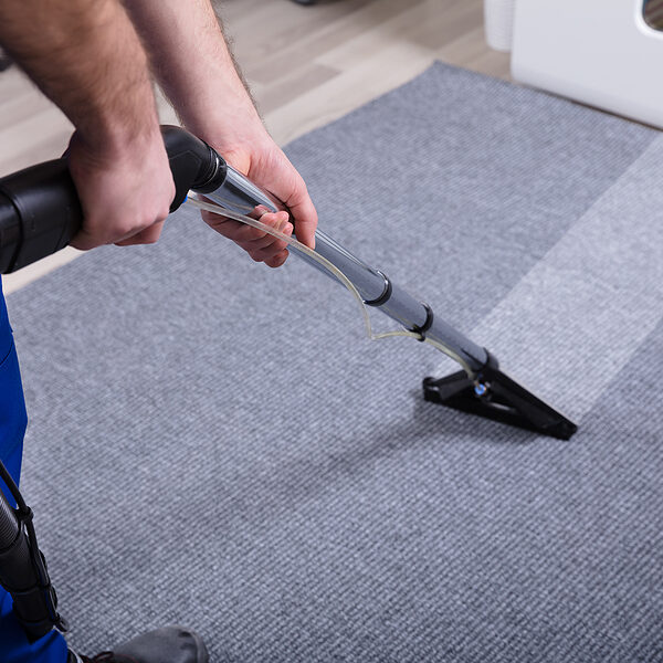 Janitor's Hand Cleaning Carpet With Vacuum Cleaner
