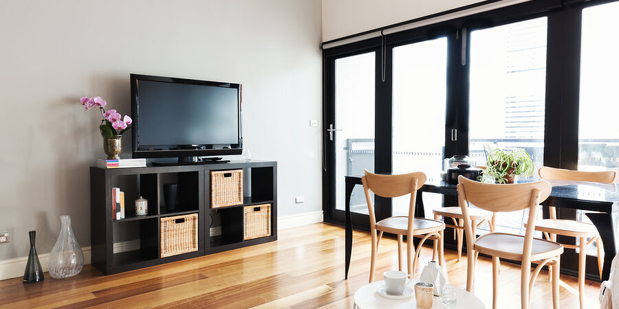 Modern apartment living room with tv on buffet and bi fold door to balcony